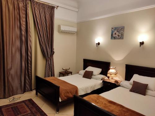 a hotel room with two beds and a window at Triomphe Hostel in Alexandria