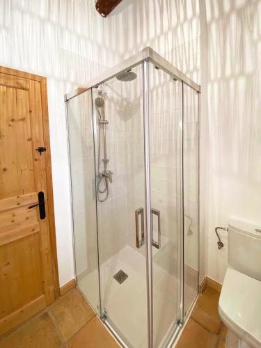 a glass shower in a bathroom with a toilet at Casa Les Germanes in Gramuntell