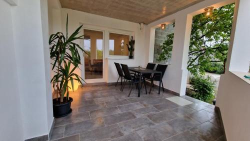 un patio con mesa, sillas y una planta en SUN RIVER KOLPA Zala, en Vinica