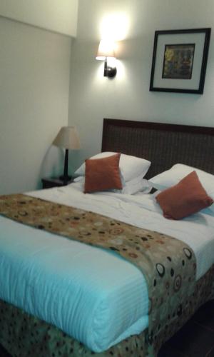 a bedroom with a large bed with white sheets and brown pillows at بورتو ساوث بيتش in Ain Sokhna