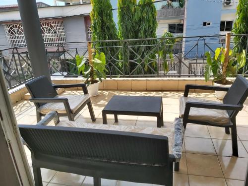 three chairs and a table on a balcony at MC Location in Abidjan