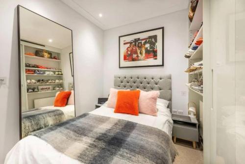 1 Schlafzimmer mit 2 Betten und einem Spiegel in der Unterkunft Stunning Mayfair 3 bed flat with terrace and fireplace in London