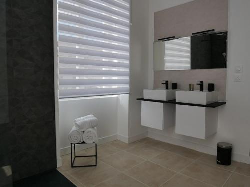 a bathroom with two sinks and a mirror at Clos de la Providence Chambres d'hôtes, piscine et Spa in Nolay