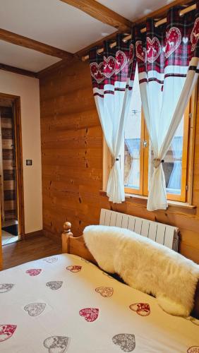 a bedroom with a bed and windows with curtains at Le Banc Des Seilles in Bonvillard