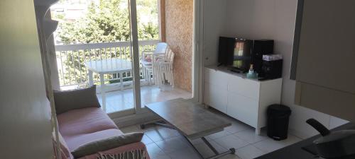 un salon avec un canapé, une table et une télévision dans l'établissement Appartement T2 climatisé dans résidence calme, à Cavalaire-sur-Mer