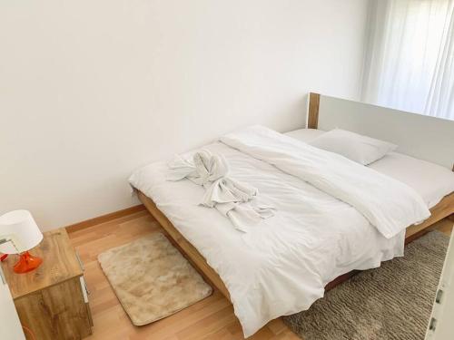 a bedroom with a white bed with a bow on it at Vivere a Locarno - 5 minuti da Piazza Grande in Locarno