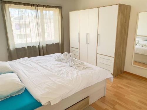 ein Schlafzimmer mit einem weißen Bett mit einer Schleife darauf in der Unterkunft Vivere a Locarno - 5 minuti da Piazza Grande in Locarno