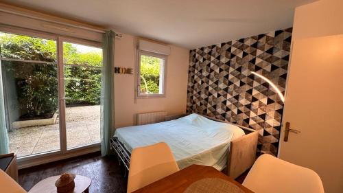 een slaapkamer met een bed in een kamer met een raam bij Appartement T2 Rez de jardin - Disneyland Paris 6 min in Bussy-Saint-Georges
