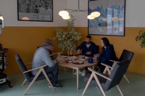 a group of people sitting around a table at Kazbegi Targmani Cottages in Stepantsminda