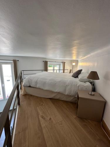 une chambre avec un grand lit et un parquet dans l'établissement Charmant studio centre ville Cannes, à Cannes