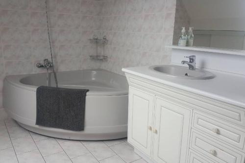 une salle de bain avec une baignoire et un lavabo dans l'établissement MAISON entre TERRE & MER - 132 M² - 2 Km de la MER, à Saint-Léonard