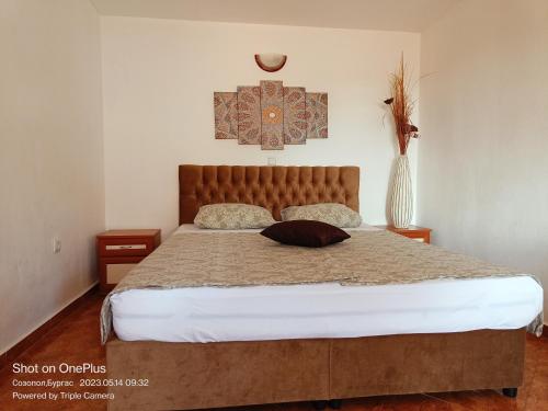 ein Schlafzimmer mit einem großen Bett mit einem Kissen darauf in der Unterkunft Moni 85 Family House in Sozopol