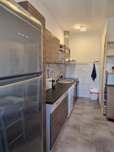 une cuisine avec un réfrigérateur en acier inoxydable et un évier dans l'établissement White House Apartman Budapest, à Budapest