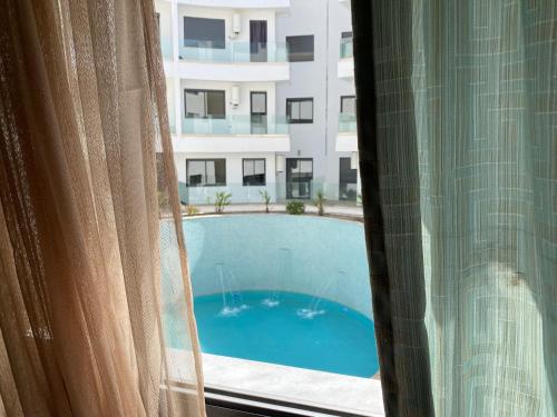Blick auf den Pool aus dem Fenster in der Unterkunft cozy appartement with swimming pool in Agadir