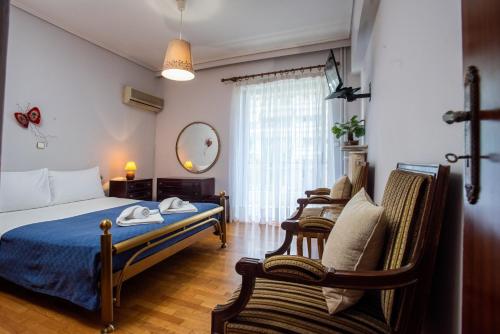 雅典的住宿－Hector's Flisvos Apartment，一间卧室配有一张床和两把椅子