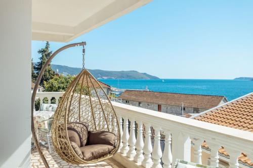 una hamaca en un balcón con vista al mar en Radic Rooms, en Herceg-Novi