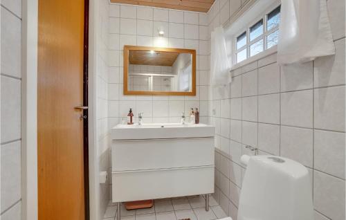 uma casa de banho com um lavatório, um espelho e um WC. em 2 Bedroom Cozy Home In Nakskov em Nakskov
