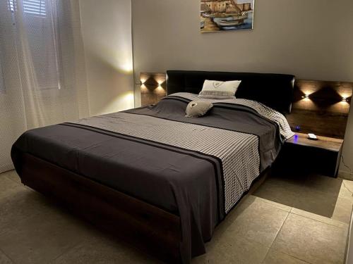 una camera da letto con un grande letto con un piumone nero di Agréable appartement vue mer a Les Issambres