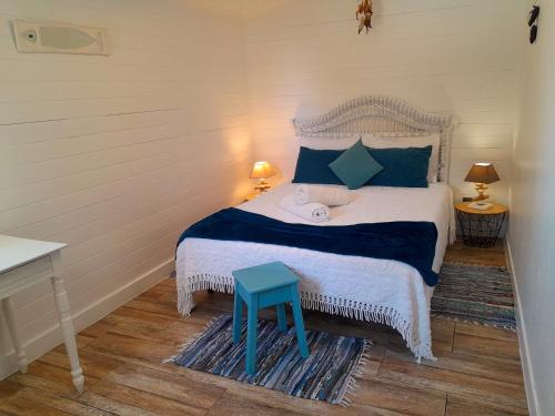a bedroom with a bed with a blue stool on it at Casa Lantana in Figueira da Foz