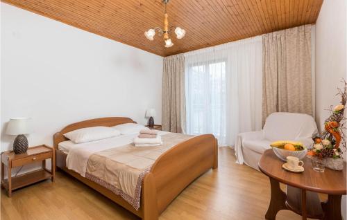 Schlafzimmer mit einem Bett, einem Tisch und einem Fenster in der Unterkunft Gorgeous Apartment In Lovran With Kitchen in Lovran