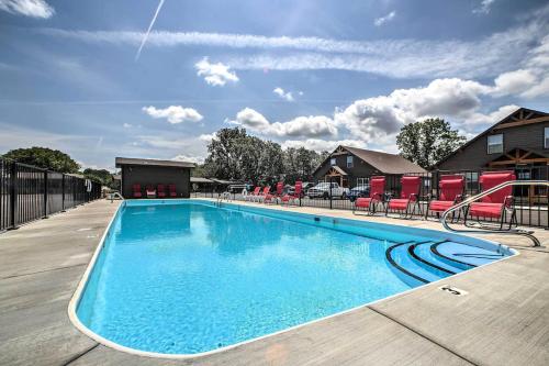 a swimming pool at a resort with red chairs at 4BD Lodge at Table Rock Lake - Near Marina - Pool - BBH in Lampe