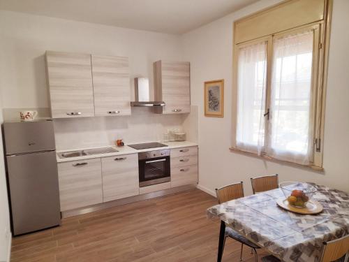uma cozinha com uma mesa e um frigorífico em La Casera em Lido di Dante
