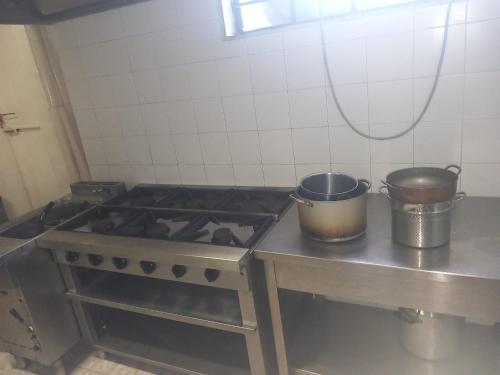 twee potten op een fornuis in de keuken bij appartamento di Domenico 