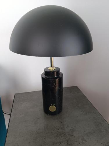 a black lamp sitting on top of a table at Clos de la Providence Chambres d'hôtes, piscine et Spa in Nolay