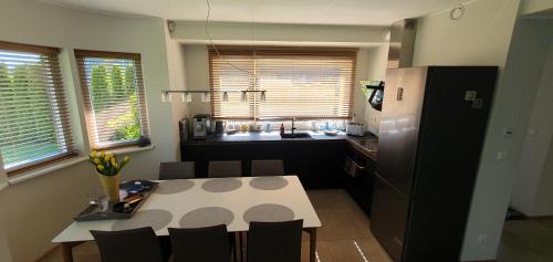 a kitchen with a table and a kitchen with a refrigerator at Elly House in Haapsalu