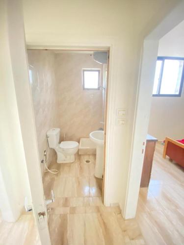 La salle de bains est pourvue de toilettes et d'un lavabo. dans l'établissement Omar home, à Madaba
