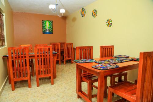 a dining room with wooden tables and wooden chairs at Palm Star Motel in Fort Portal