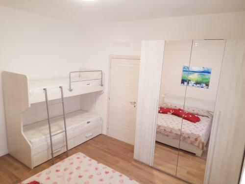 a small bedroom with a bunk bed and a mirror at La Casera in Lido di Dante