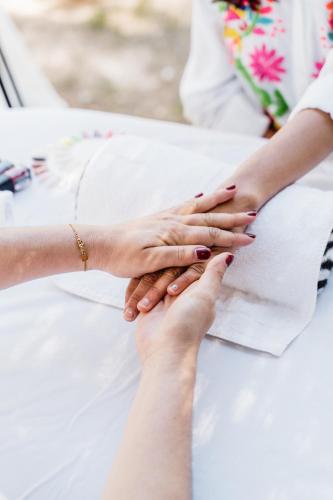 a group of people stacking their hands on a bed at Can Vistabella Boutique Resort in San Antonio