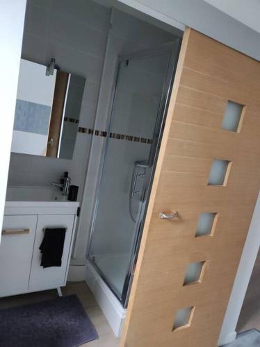 une salle de bain avec douche et porte vitrée dans l'établissement Smart house airport CDG, Astérix, à Louvres