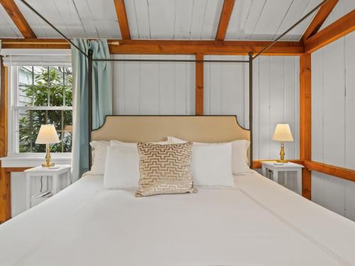 1 dormitorio con 1 cama blanca grande y 2 lámparas en The Seagrove Suites & Guest Rooms, en Eastham