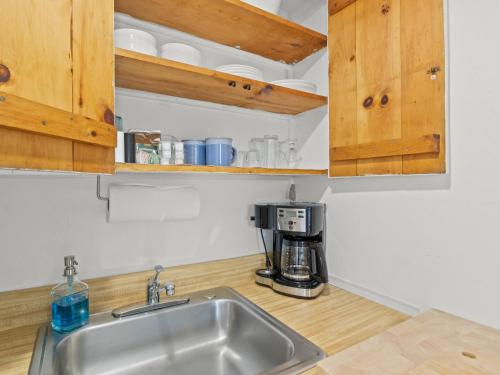 a kitchen with a sink and a coffee maker at The Seagrove Suites & Guest Rooms in Eastham