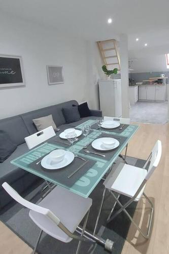 - une table avec des assiettes et des chaises dans le salon dans l'établissement Smart house airport CDG, Astérix, à Louvres