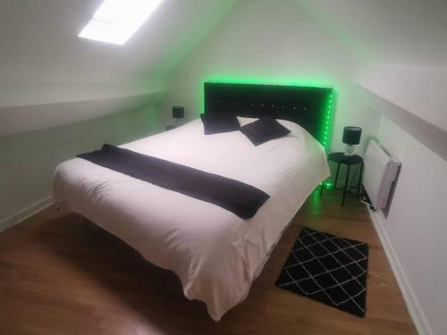 ein Schlafzimmer mit einem weißen Bett mit einem grünen Kopfteil in der Unterkunft Smart house airport CDG, Astérix in Louvres