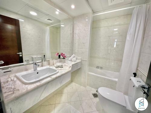 a bathroom with a sink and a toilet and a tub at Apartments at Business Bay by Bhavan Vacation Homes in Dubai