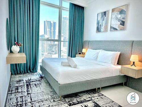 sypialnia z dużym łóżkiem i dużym oknem w obiekcie Apartments at Business Bay by Bhavan Vacation Homes w Dubaju