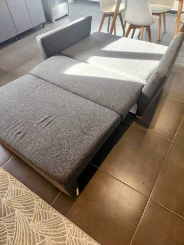 a couch sitting on the floor in a room at Modern sunshine yellow apartment with nature views in Willemstad