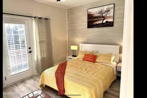1 dormitorio con 1 cama y un árbol en la pared en Vacation home next to the beach! en Panama City Beach