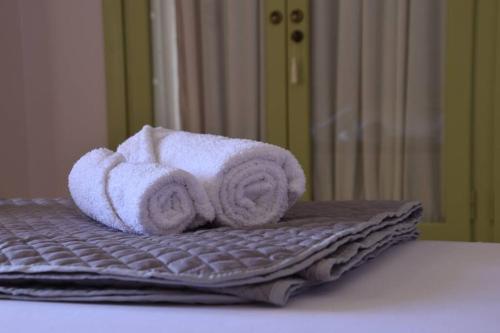 a pile of towels sitting on top of a bed at Villa Palli - Βίλα με θέα θάλασσα και μεγάλο μπαλκόνι in Vathí