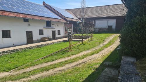 Una casa con un patio con paneles solares. en Ubytování Na statku, en Matějov