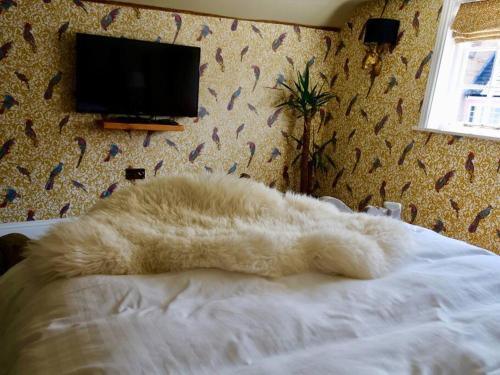 a white blanket laying on a bed in a bedroom at Huge Luxury 8 Bed Manor House Hot Tub Pool Table in Saffron Walden