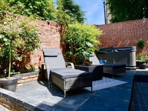 a patio with two wicker chairs and a table at Huge Luxury 8 Bed Manor House Hot Tub Pool Table in Saffron Walden