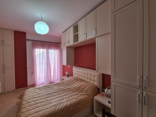a small bedroom with a bed and a window at Redsun City Center Apartment in Vlorë