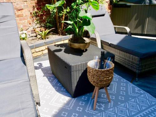 a patio with a table and a chair and a plant at Huge Luxury 8 Bed Manor House Hot Tub Pool Table in Saffron Walden