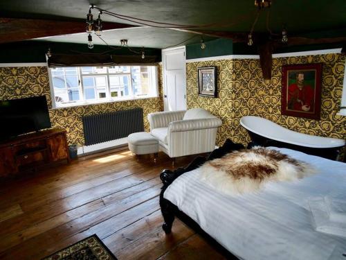 ein Schlafzimmer mit einem Bett, einem Sofa und einem TV in der Unterkunft Contractors Deluxe Essex Short Stay House In Saffron Walden Near Cambridge in Saffron Walden