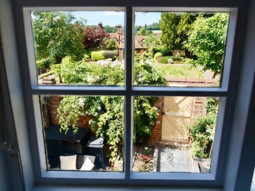 a view through a window of a garden at Huge Luxury 8 Bed Manor House Hot Tub Pool Table in Saffron Walden